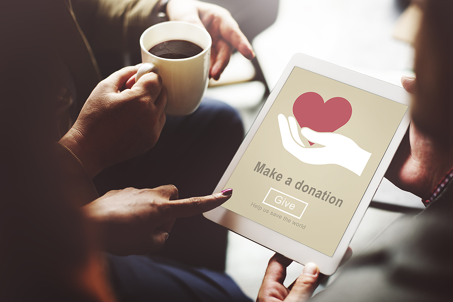 image of hand holding coffee with someone else's hand holding ipad ready to make online donation