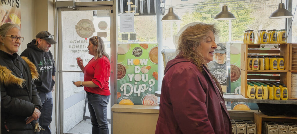 Our staff handing out wooden nickels to customers at CourseVector's Valentine's Day 2024 community outreach event in partnership with Philly Pretzel Factory in Camp Hill, PA