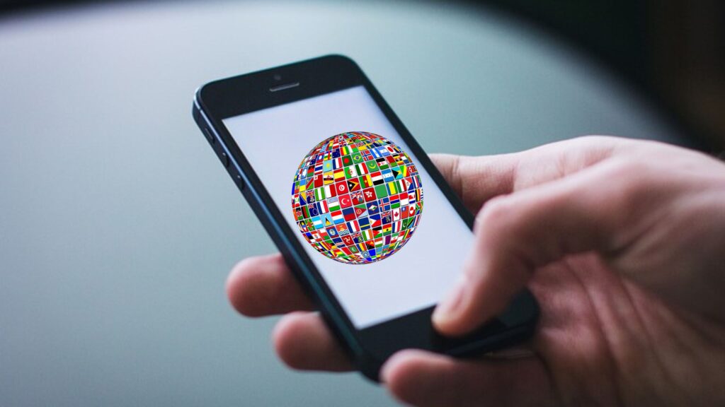 holding a cell phone with a globe full of maps